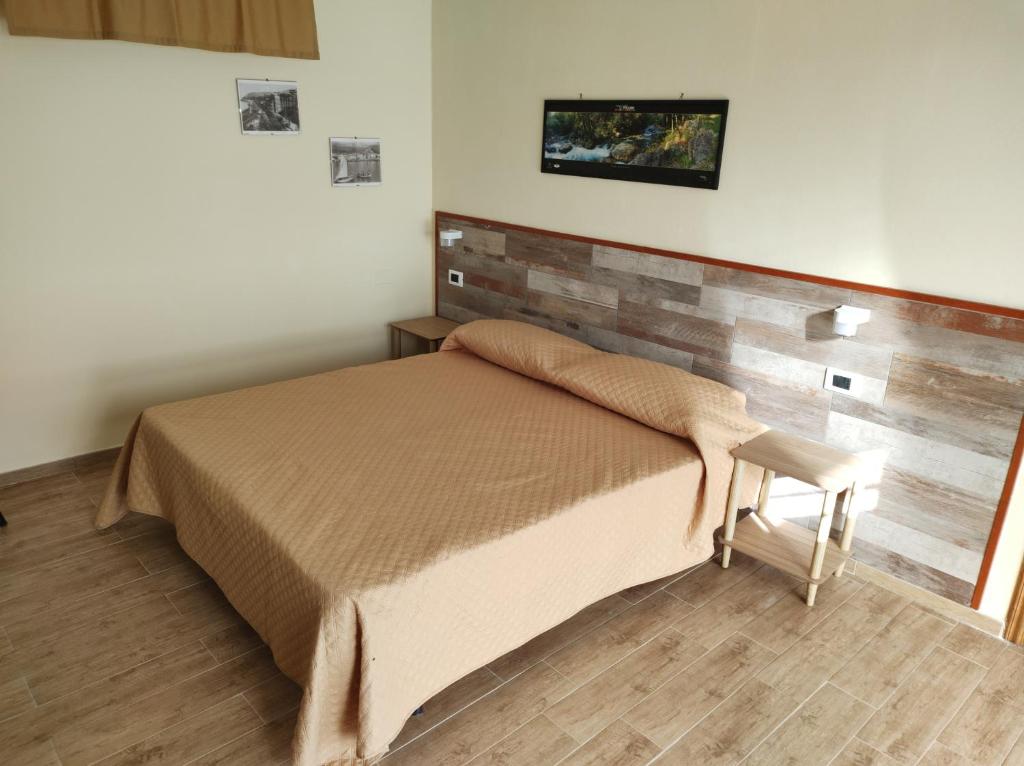 una camera con letto e testiera in legno di CERSETO 2 a Santa Domenica Talao