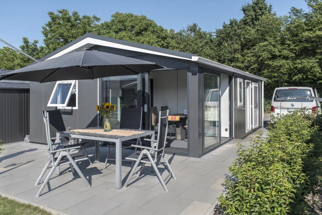 a large black shed with a table and an umbrella at Haus Ferdi in Koblenz