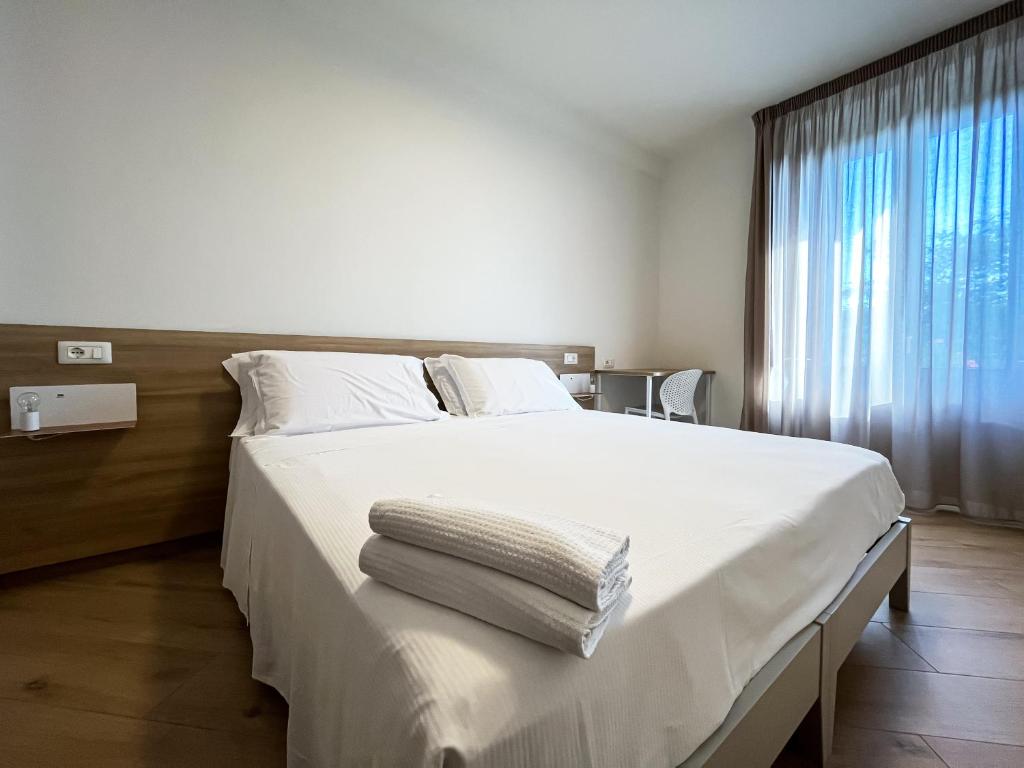 een slaapkamer met een groot wit bed en handdoeken bij Appartamento con Vista Montagna in Pietrapertosa
