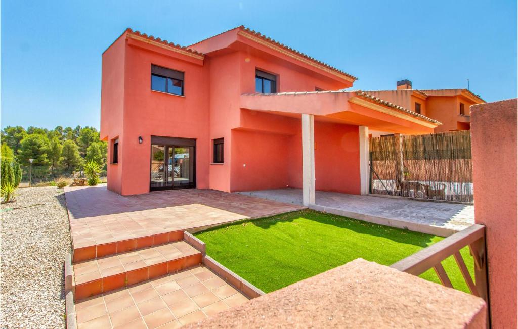 a red house with a lawn in front of it at Beautiful Home In Caravaca De La Cruz With Kitchen in Caravaca de la Cruz