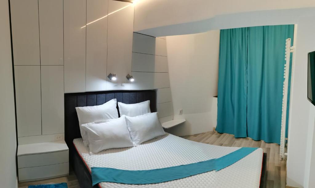 1 dormitorio con 1 cama con cortina azul en Mara Park, en Baia Mare