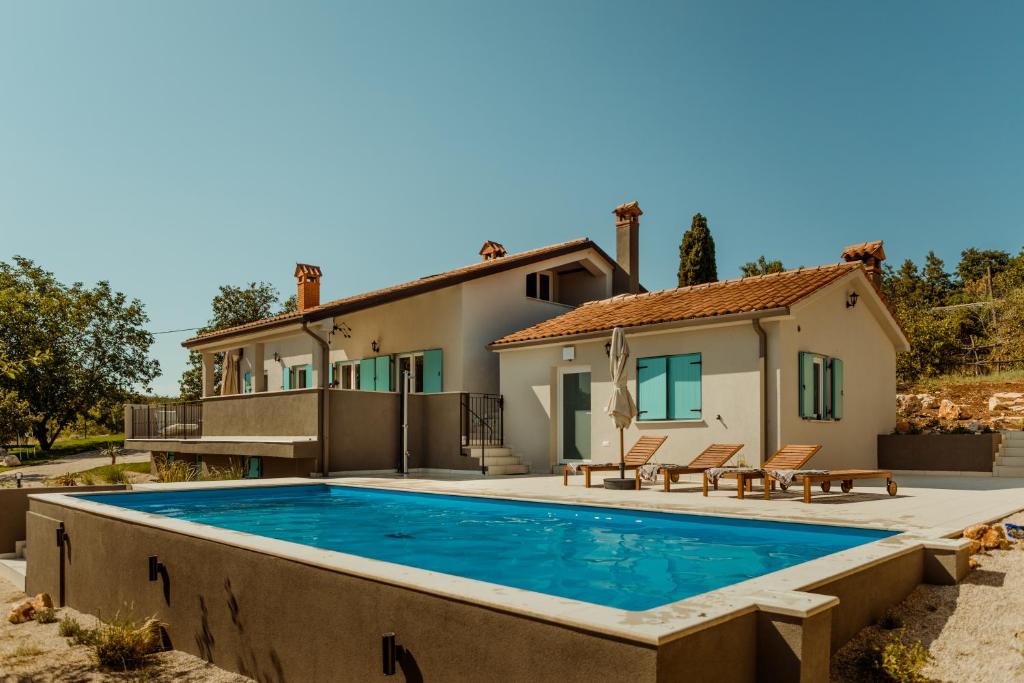 a villa with a swimming pool and a house at Casa Cavi Istria in Oprtalj