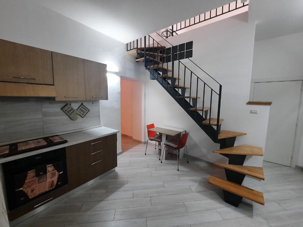 a kitchen with a spiral staircase and a table at La Casa del Pellegrino in Tuscania