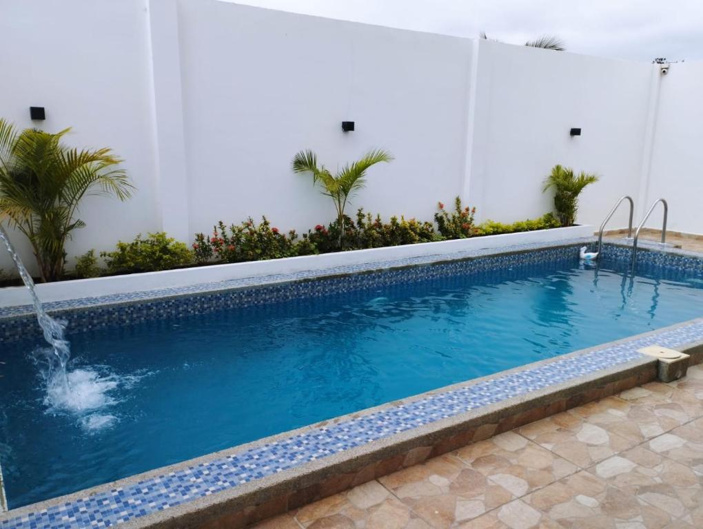 a swimming pool with blue water in a building at Hostal Las Orquideas in Manta