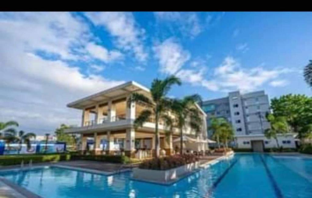 a building with a swimming pool in front of a building at Caren 8-Spatial Condo Maa 2br fully-furnished wtih unli Pool access in Ma-a