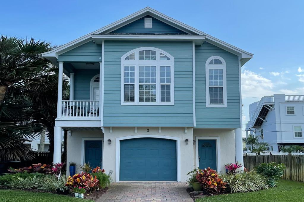 una casa azul con garaje en Island Breeze en St. Augustine