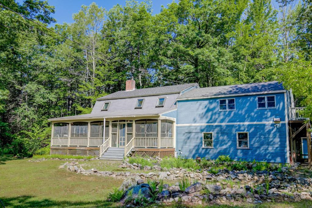 una casa azul en medio de un patio en Tuftonboro Retreat, en Tuftonboro