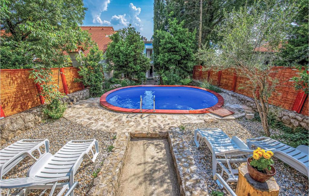 a backyard with a swimming pool and chairs at 3 Bedroom Pet Friendly Home In Dramalj in Dramalj