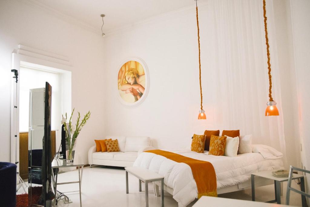a white bedroom with a bed and a couch at El Sueño Hotel & Spa in Puebla