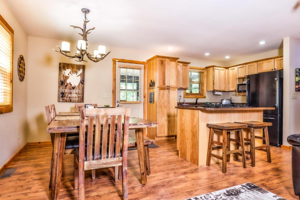 eine Küche mit einem Tisch und Stühlen sowie einem Kühlschrank in der Unterkunft Bear Paw Hideaway in Lac du Flambeau