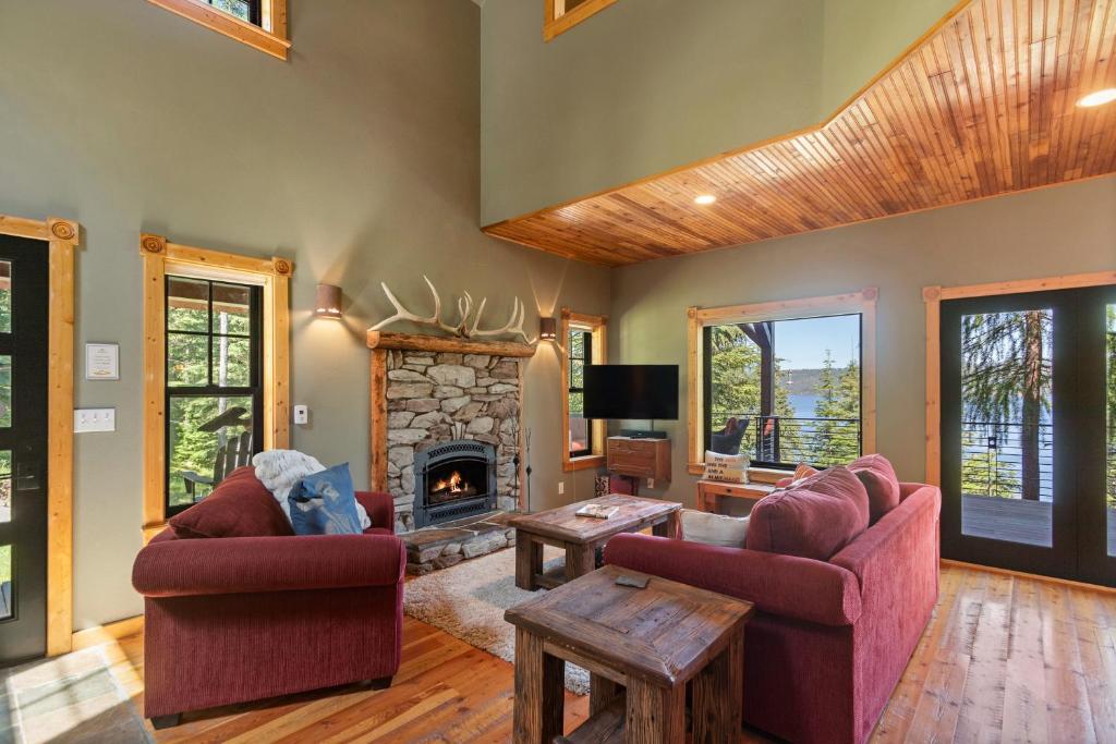 ein Wohnzimmer mit 2 Stühlen und einem Kamin in der Unterkunft Stoneridge Pines Cabin in Harrison