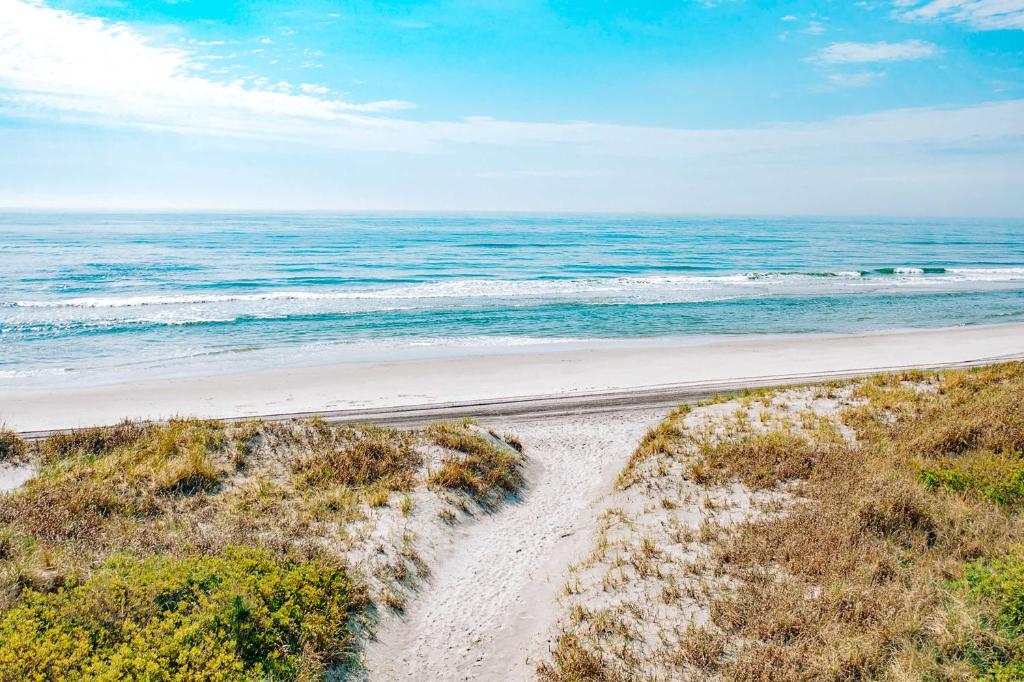an empty beach with the ocean in the background at Beautiful Brigantine Condo - Walk to Beach! in Brigantine