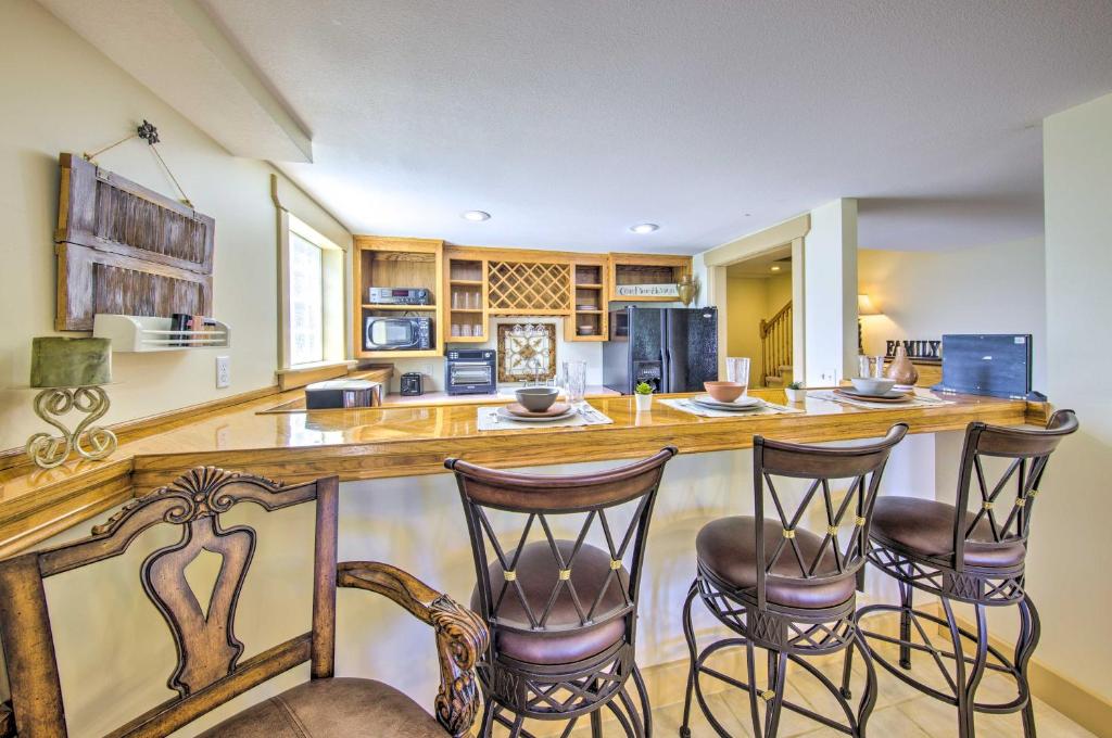 una cocina con una barra con tres taburetes en Kansas Countryside Studio with Swimming Pond!, en Fontana