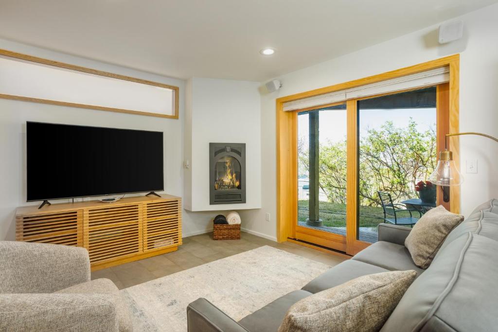 un salon avec une télévision à écran plat et un canapé dans l'établissement Downtown Contemporary Coastal Condo, à Anchorage