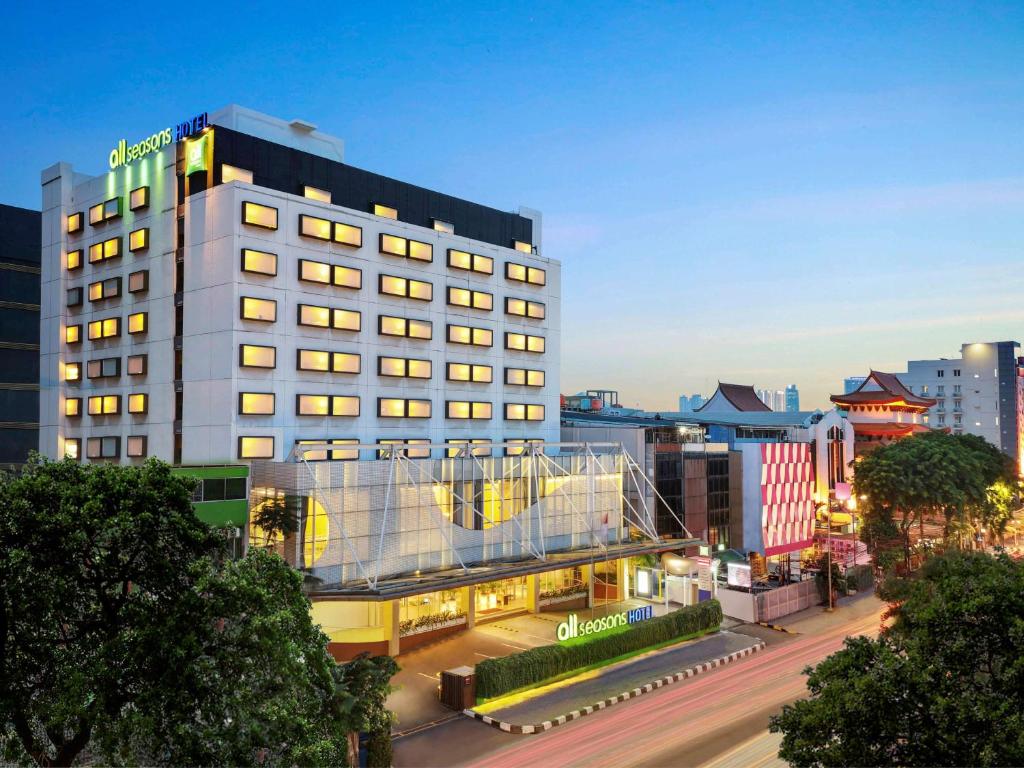 a building with a lit up facade in a city at ibis Styles Jakarta Gajah Mada in Jakarta