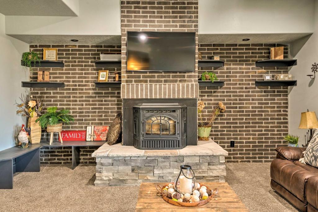 a living room with a brick fireplace with a tv at Spacious Tooele Unit with Sprawling Mtn Views! in Tooele
