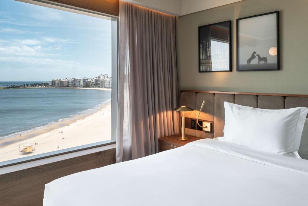 蒙特維多的住宿－Hotel Costanero MGallery - ACCOR，一间卧室配有一张床,享有海滩美景