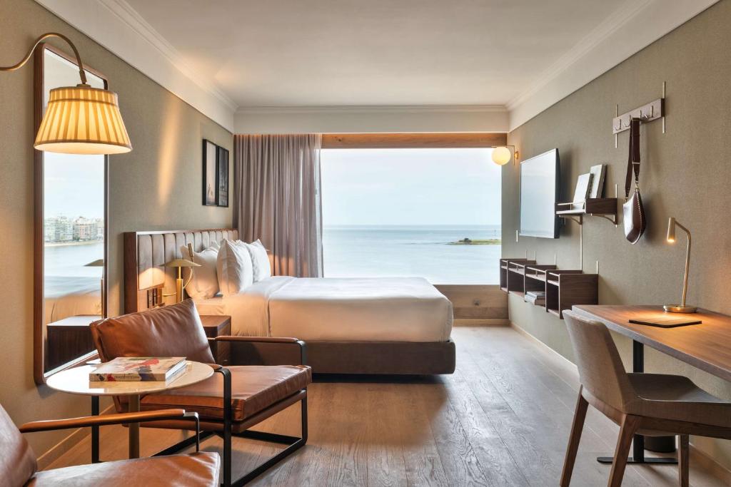 モンテビデオにあるHotel Costanero MGallery - ACCORのベッド付きのホテルルームで、海の景色を望めます。