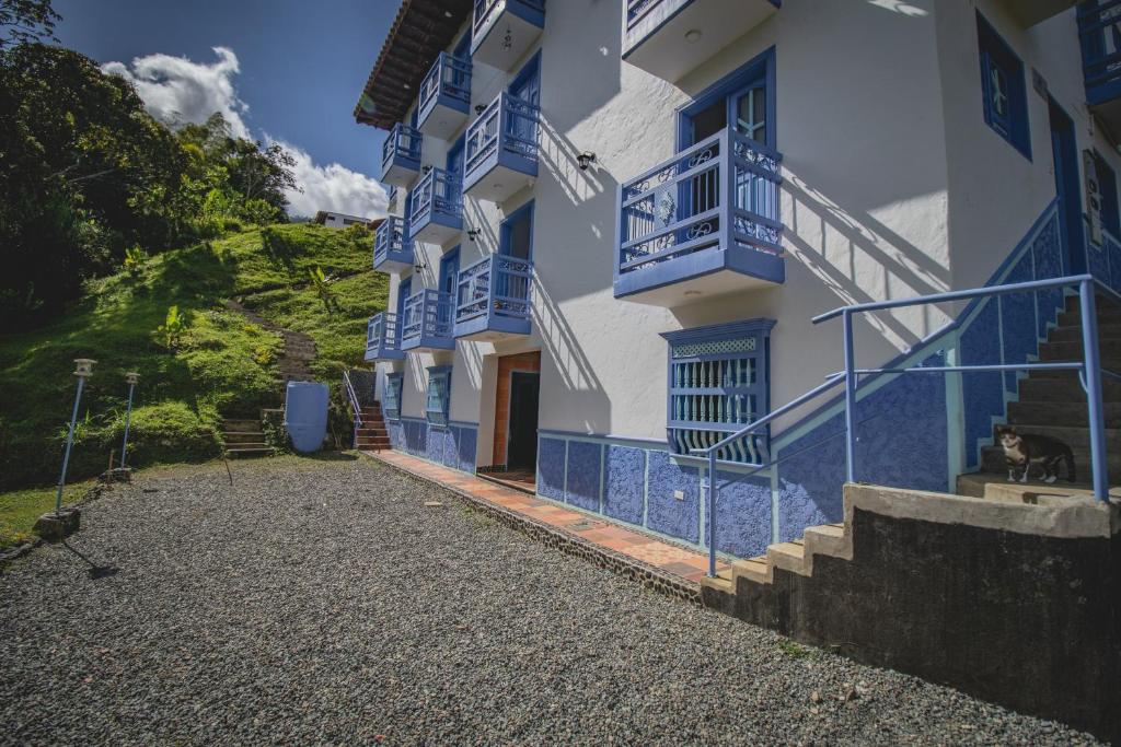 un edificio con balcones azules y escaleras. en Apartahotel Villa carolina 1, en Jericó