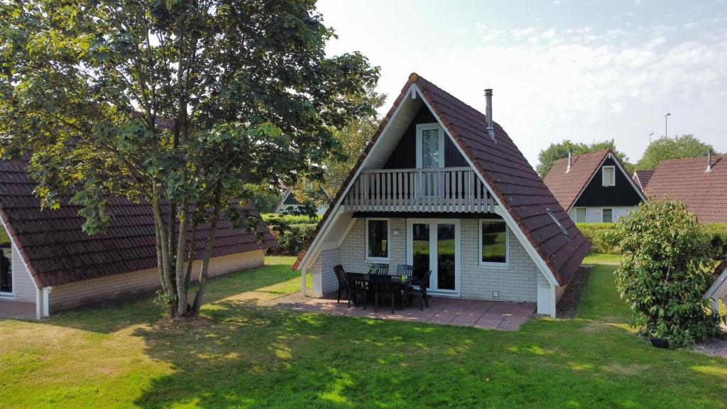 una pequeña casa blanca con techo de gambrel en Gezellig vakantiehuis 't Gramsbergje, en Gramsbergen