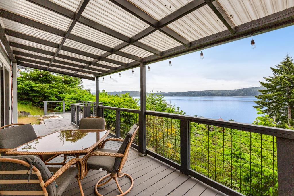 a deck with a table and chairs and a view of the water at Hoodsport Hideaway in Hoodsport