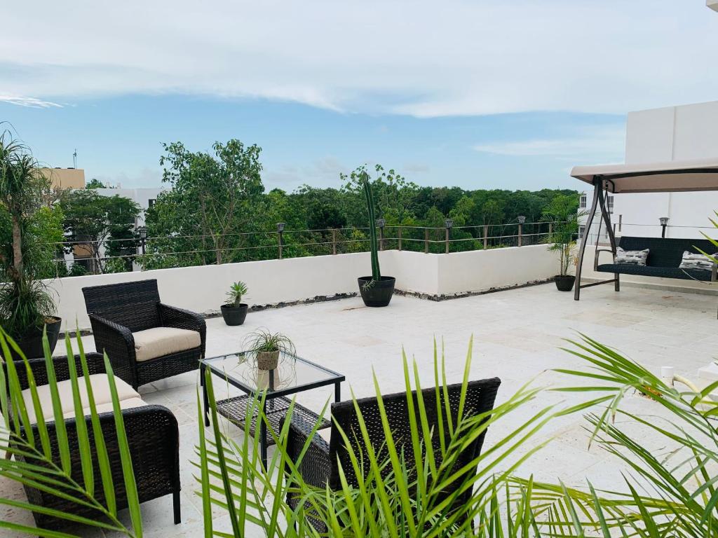 un patio con sillas y mesas en un balcón en Franks House Apartment "Shared House" en Cancún