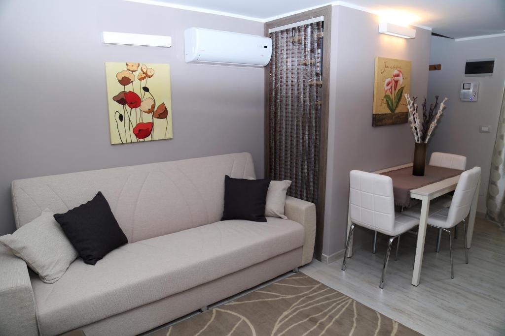 uma sala de estar com um sofá e uma mesa em Appartamento Dante em Catânia