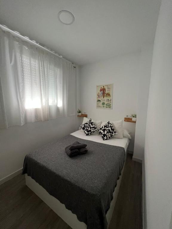 biała sypialnia z łóżkiem z czarnym kocem w obiekcie Suite by Hawkins Atico w mieście Algeciras