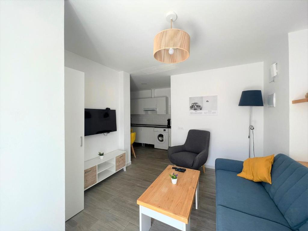 salon z niebieską kanapą i stołem w obiekcie Suite by Hawkins Atico w mieście Algeciras