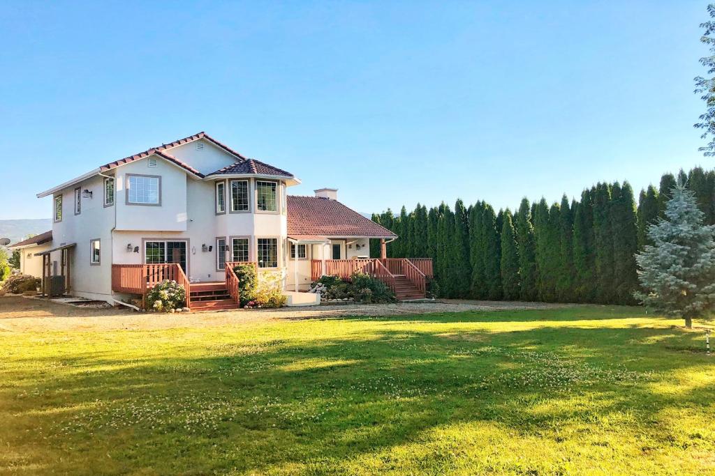 uma casa com um grande quintal com um relvado verde em House Of Serenity em East Wenatchee