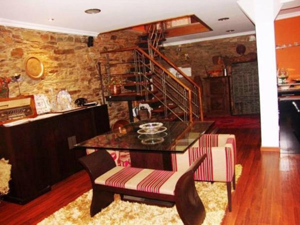 a dining room with a table and a staircase at Casa do Soto in Milhão