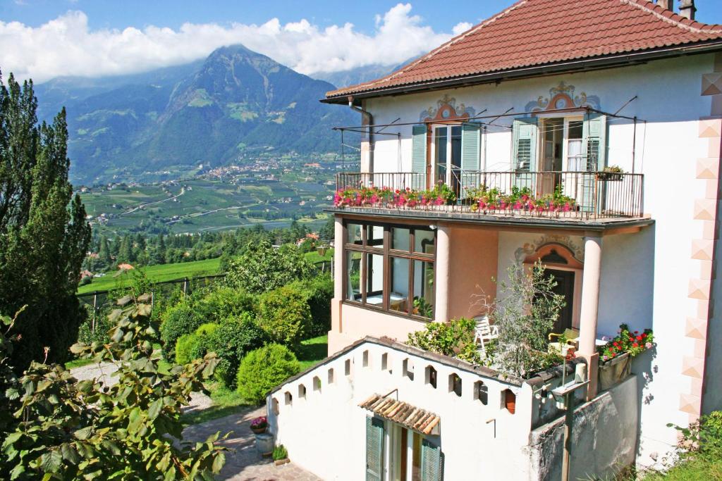 a house with flowers on the balconies and a valley at Lindenhof Residence Meran in Merano