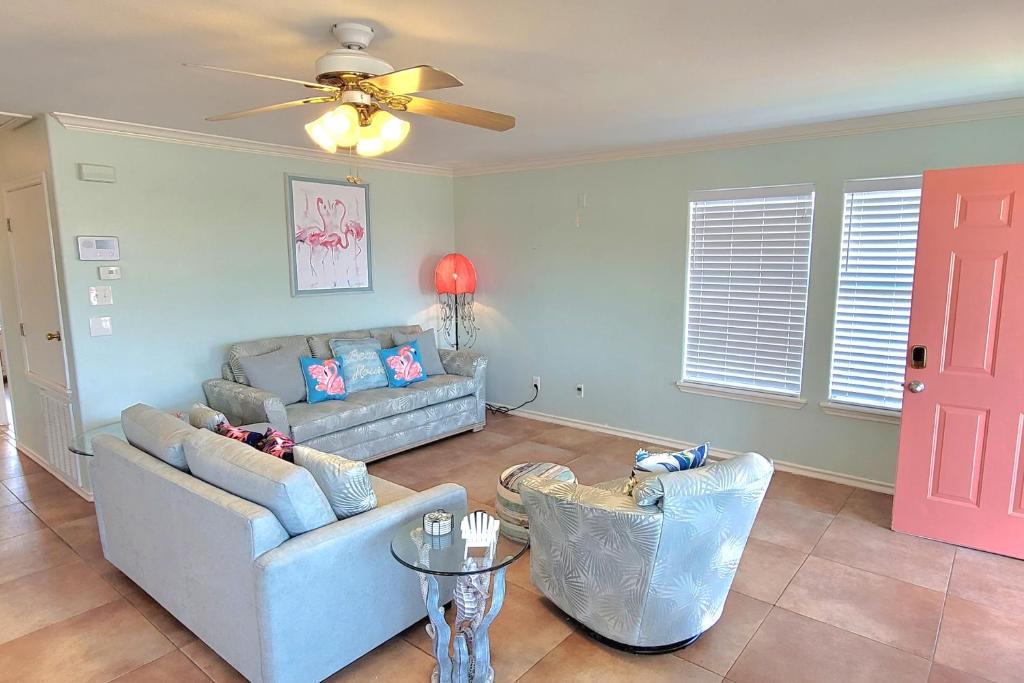een woonkamer met een bank en een plafondventilator bij Flamingo Lagoon in Corpus Christi
