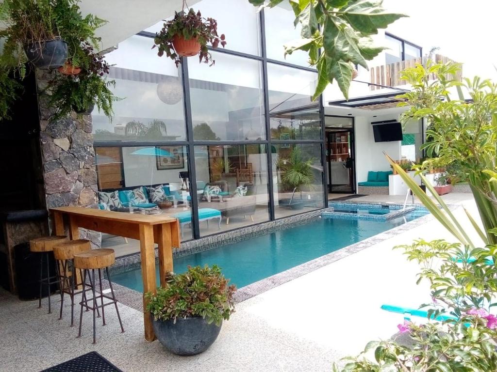 una casa con piscina e tavolo e alcune piante di Casa Nicolás a Valle de Bravo