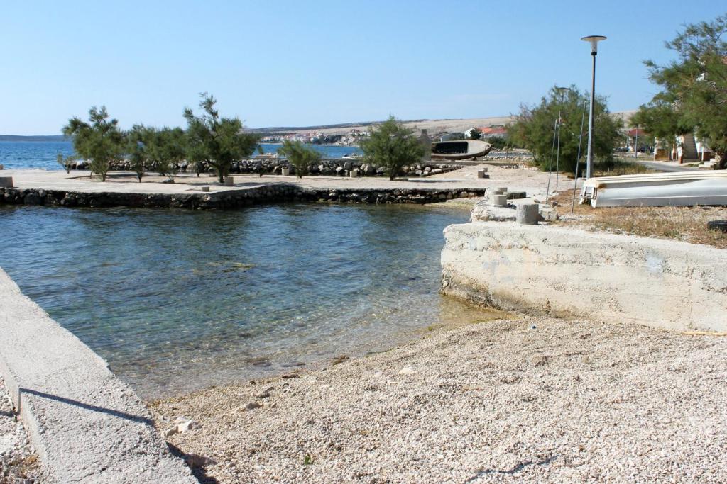 ein Wasserkörper neben einem Strand mit Bäumen in der Unterkunft Rooms by the sea Kustici, Pag - 6288 in Kustići