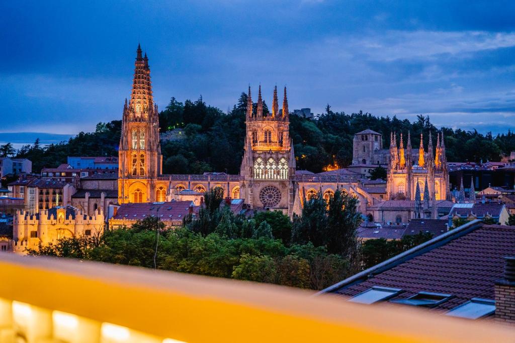 a view of a city skyline at night at Catedral - Apartamentos Burgos Deluxe in Burgos