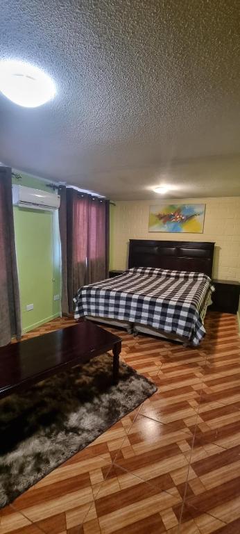 1 dormitorio con 1 cama y suelo de madera en Casa Enea Pudahuel en Santiago