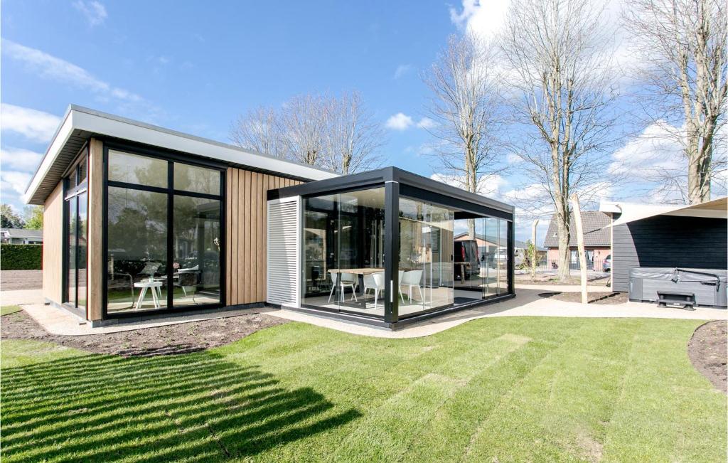 een modern huis met grote ramen en een gazon bij Nice Home In Voorthuizen With Wifi in Voorthuizen