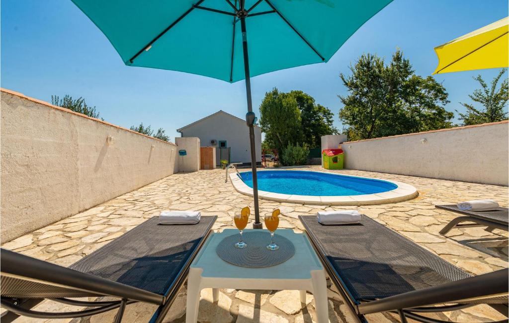 a patio with a table and an umbrella and a pool at Nice Home In Podgradina With 3 Bedrooms, Wifi And Outdoor Swimming Pool in Gradina