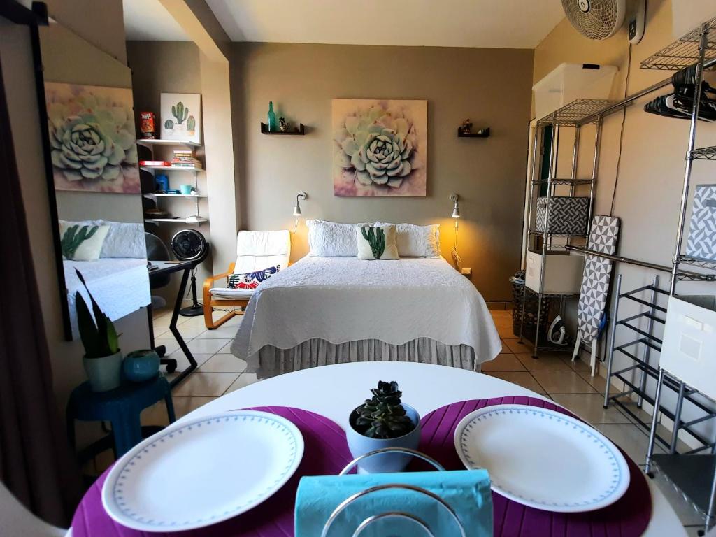 a room with a bed and two tables and shelves at Cómodo Apartamento privado in Tegucigalpa
