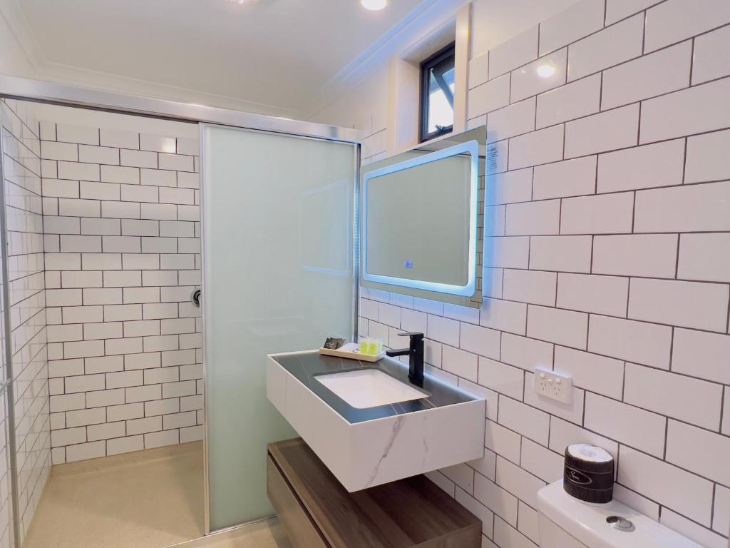 a bathroom with a sink and a mirror at Sandpiper Motel Apollo Bay in Apollo Bay