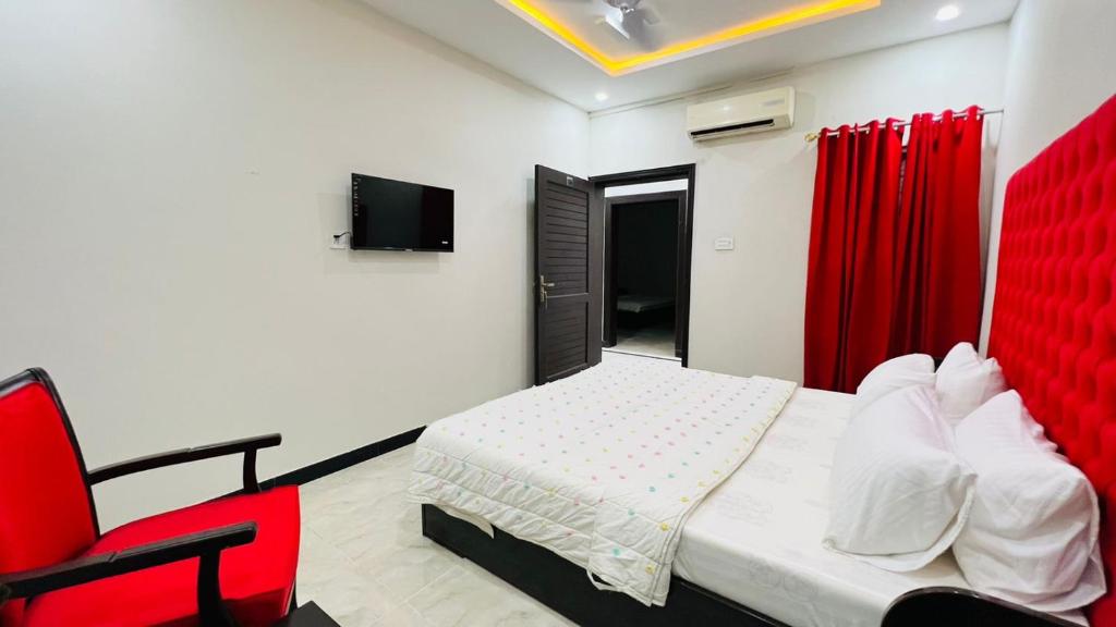 a bedroom with a bed and a red chair at Hotel Double1 in Islamabad