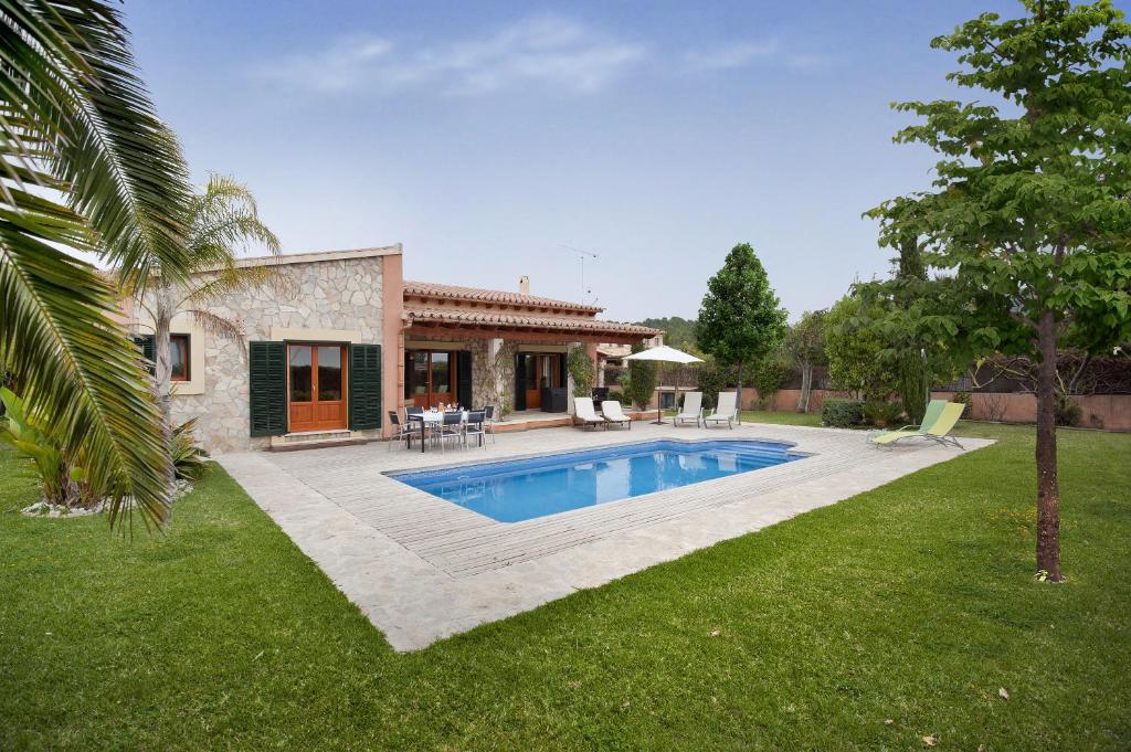 a house with a swimming pool in a yard at Ubac Pollença in Sa Pobla