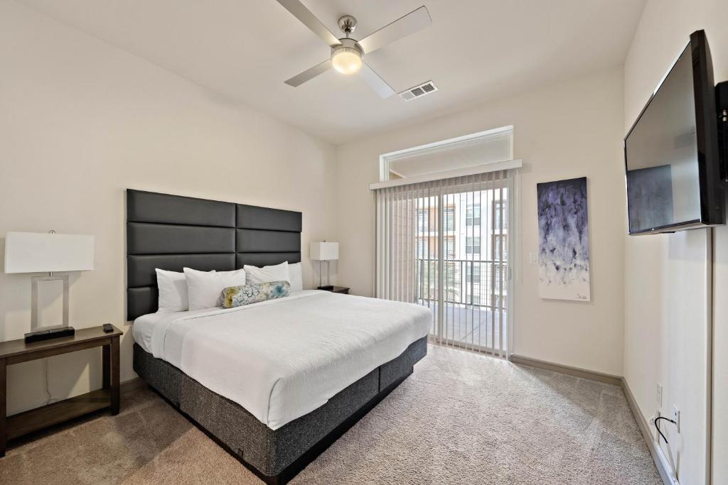 a bedroom with a large bed and a ceiling fan at RENU at Downtown Houston in Houston