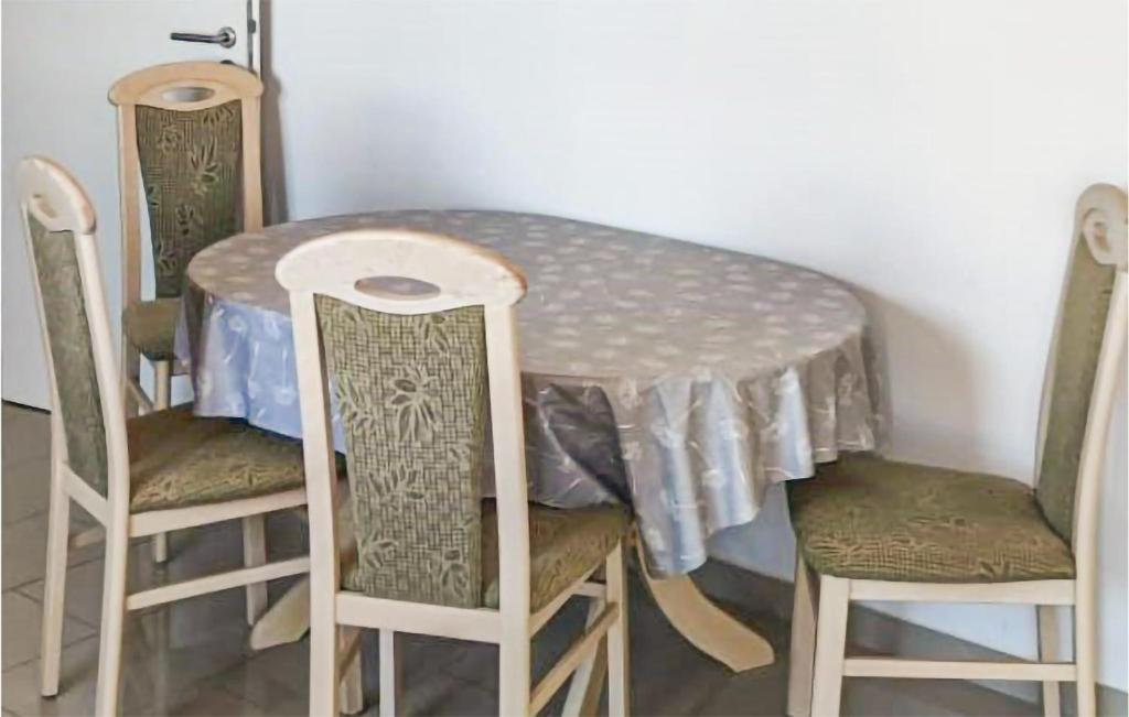 stół jadalny z krzesłami i stół z obrusem w obiekcie 2 Bedroom Cozy Apartment In Krakow Am See w mieście Krakow am See