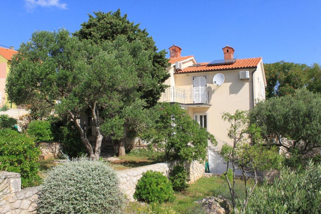 a house on a hill with trees in front of it at Apartments with a parking space Nerezine, Losinj - 2518 in Nerezine
