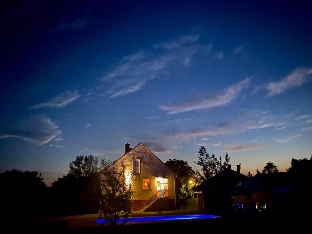 Una casa iluminada por la noche con luces encendidas en River House - Luxury house on the border of the Tisza River, en Ároktő