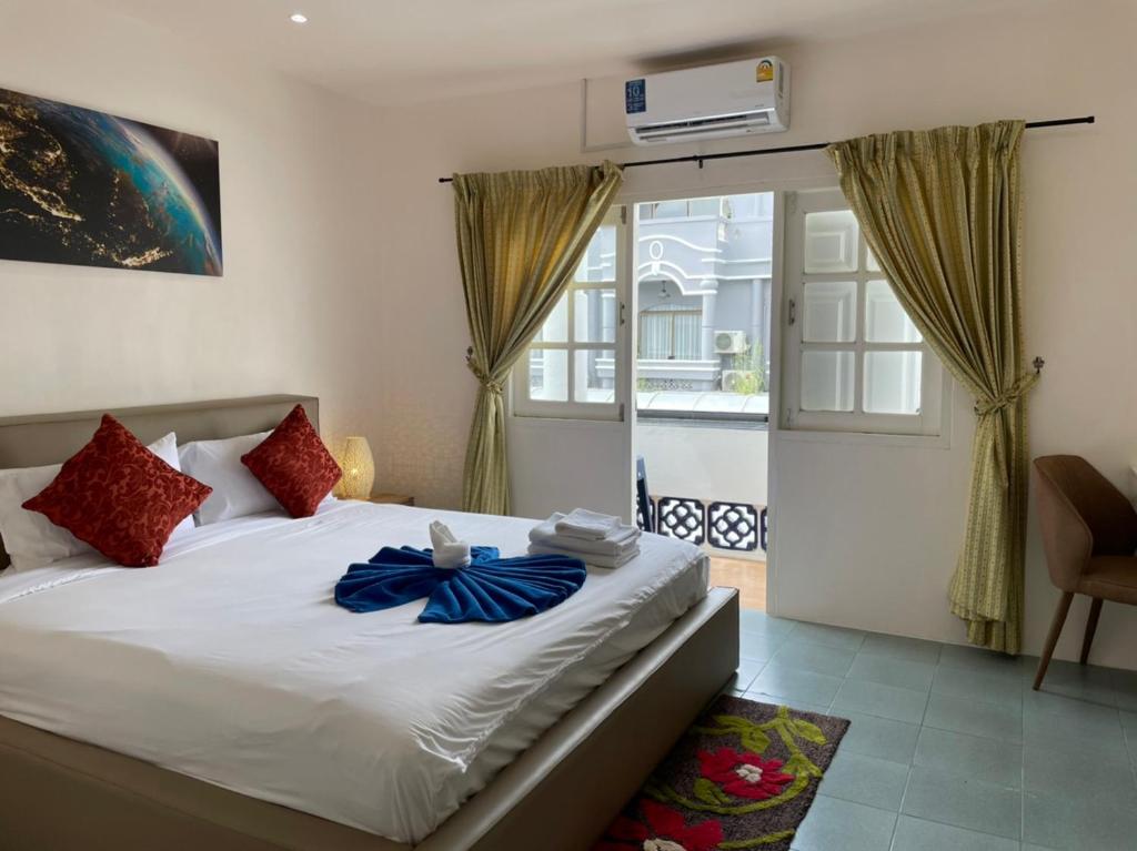 a bedroom with a bed and a sliding glass door at Inn Dulgence in Patong Beach