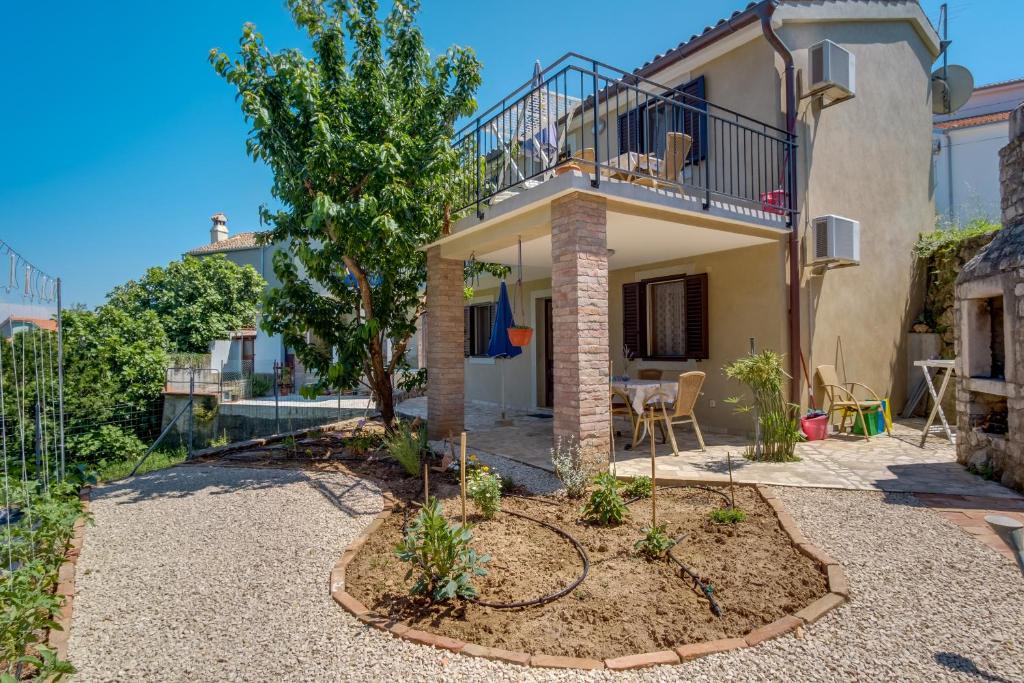 a house with a balcony and a patio at Apartments by the sea Nerezine, Losinj - 2519 in Nerezine