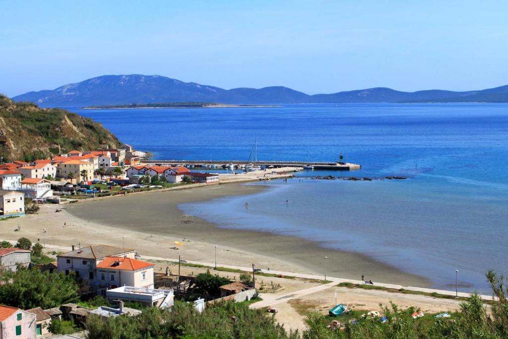 - une vue sur une plage avec une jetée dans l'eau dans l'établissement Apartments by the sea Susak, Losinj - 14713, à Susak